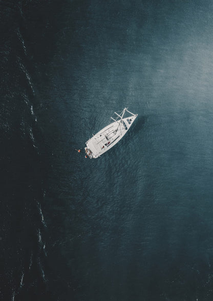 white sailboat on dark turquoise water.