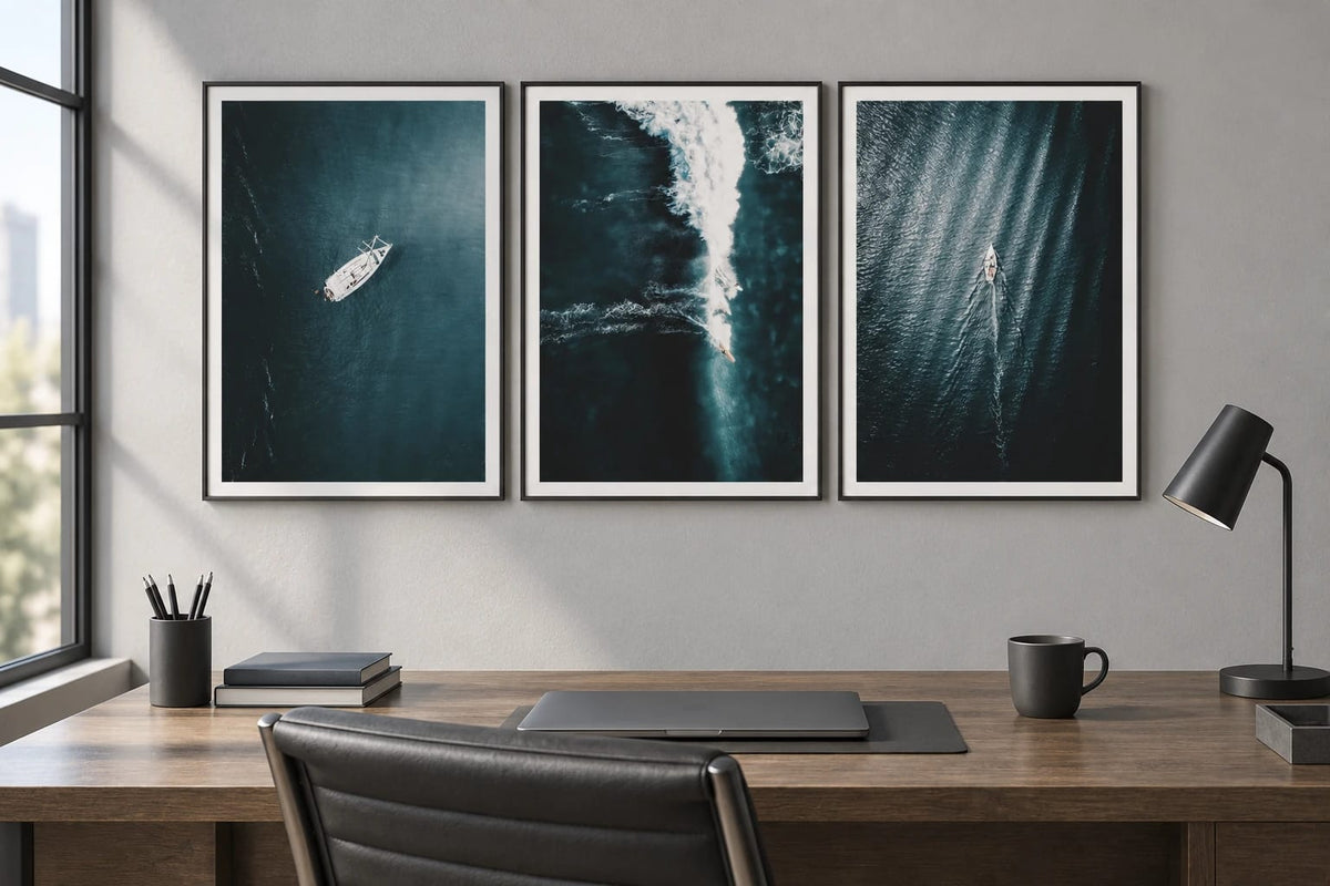 Three marine prints above a desk in a gray office.