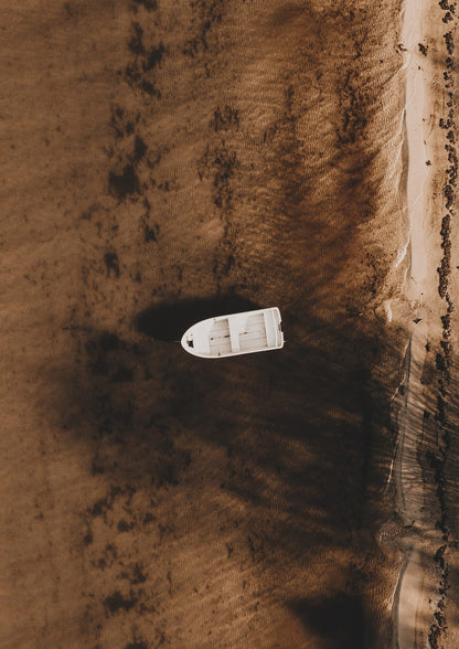 white boat on amber shallows near shore.