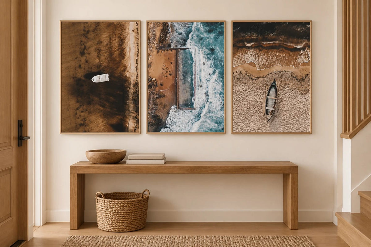 Three boat and shoreline prints above an oak entry console.