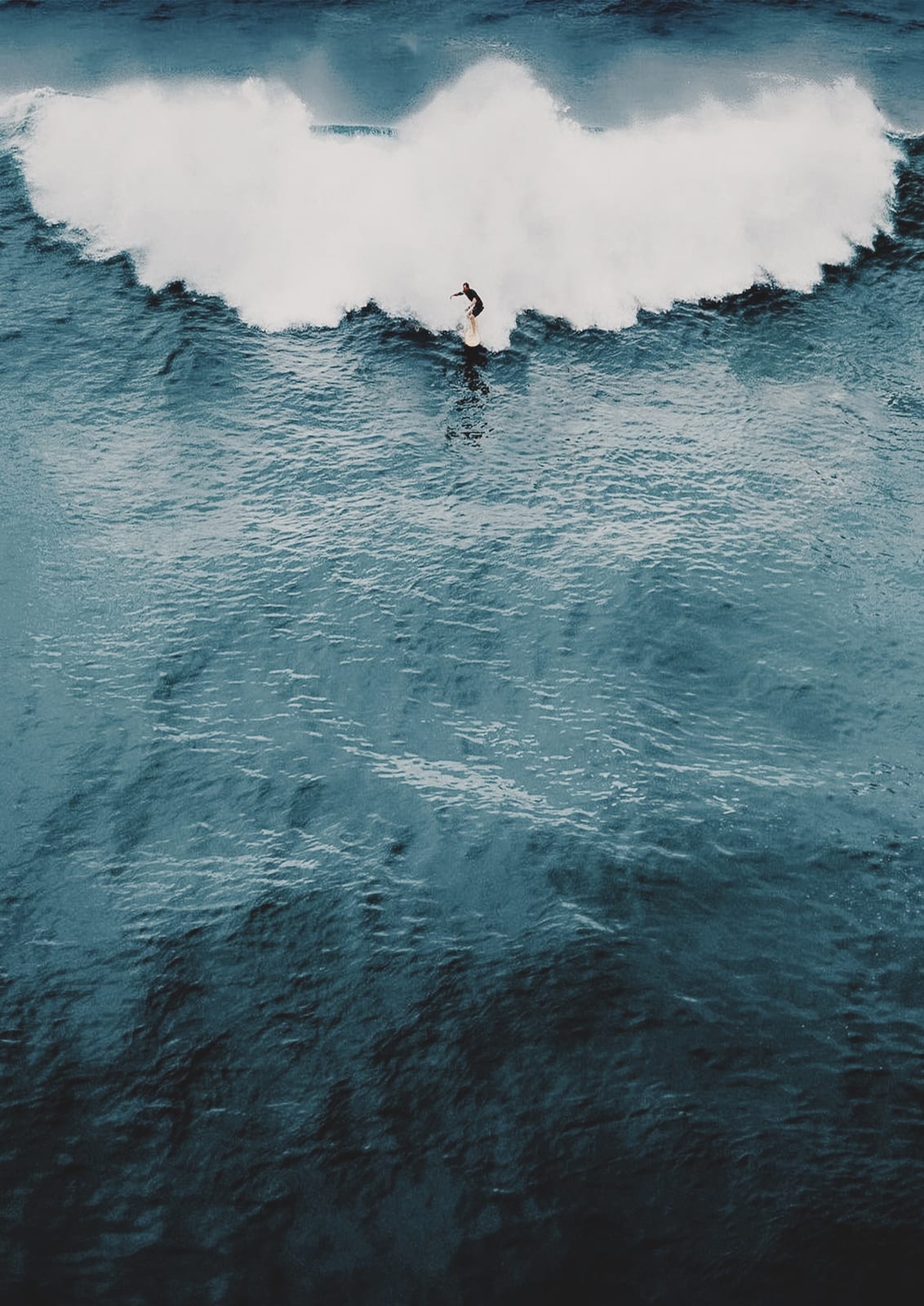 surfer before a breaking white wave.