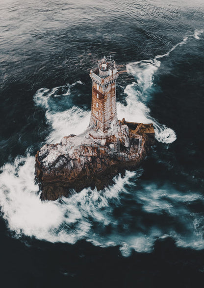 lighthouse on a rocky island amid foam.