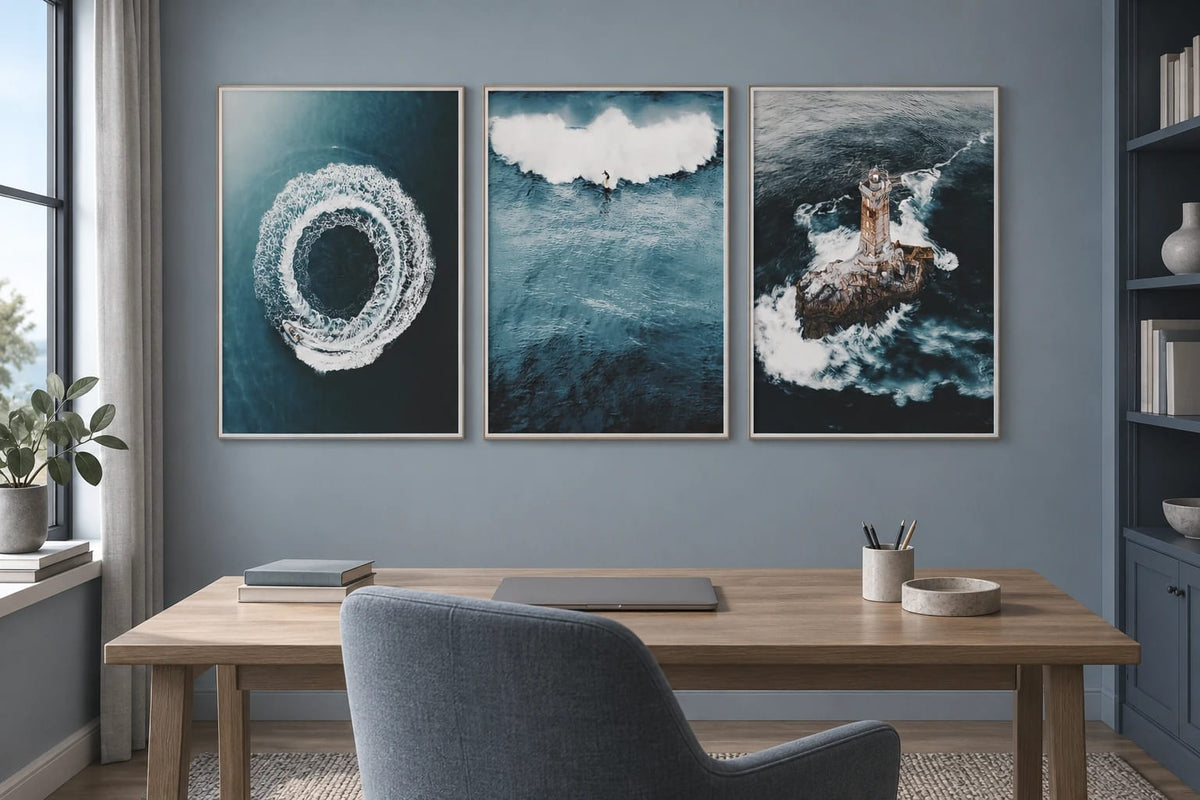 Three marine prints in a gray-blue office above a wood desk.