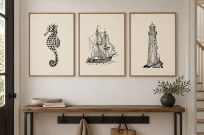 Three coastal line-art prints above a wood entry console.