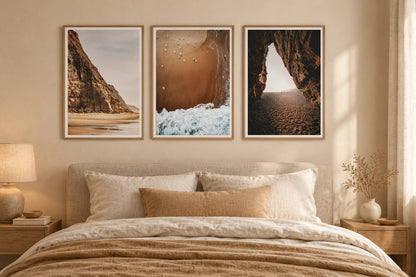 Three shore views above a bed in a beige bedroom.