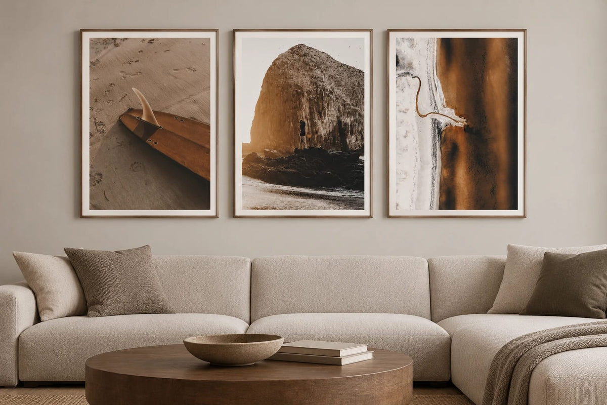 Three beach prints above a light sofa.