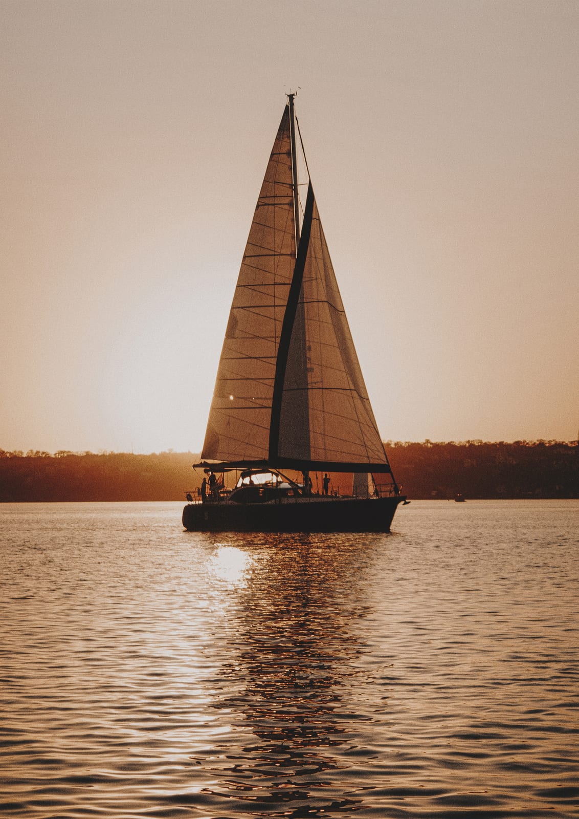 sailboat against a warm sunset.
