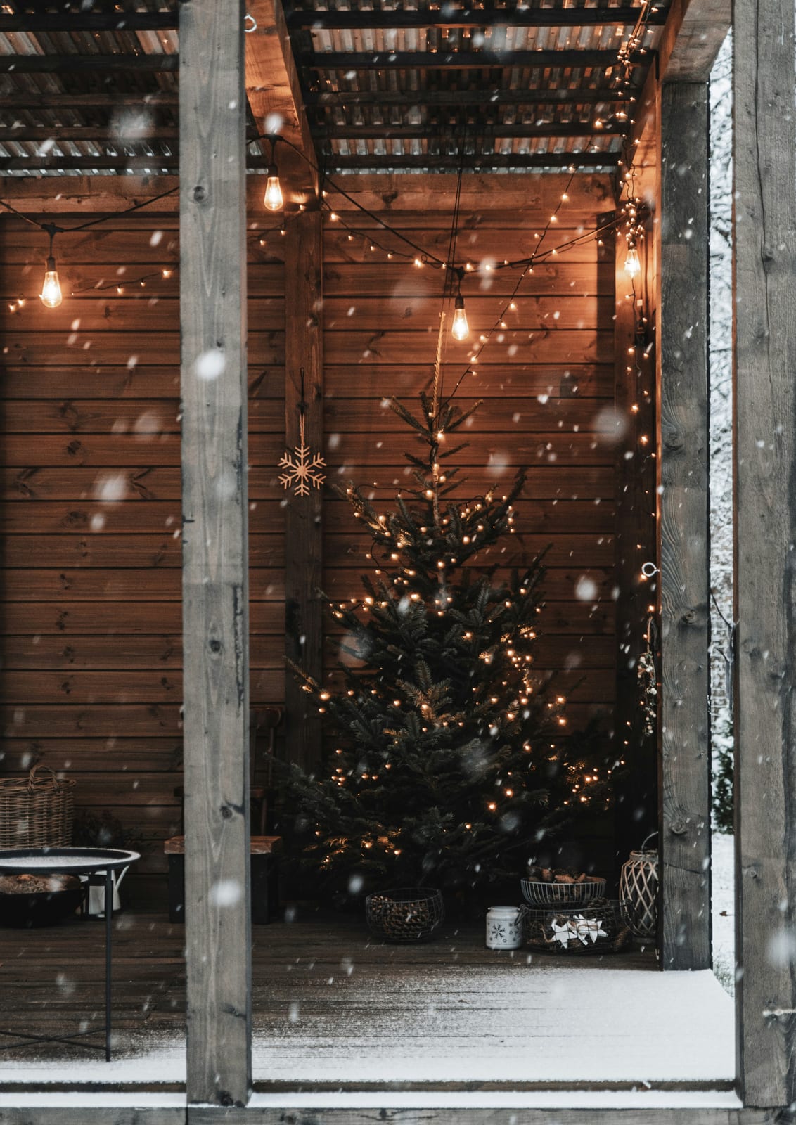 wood shelter with a decorated tree and lights.