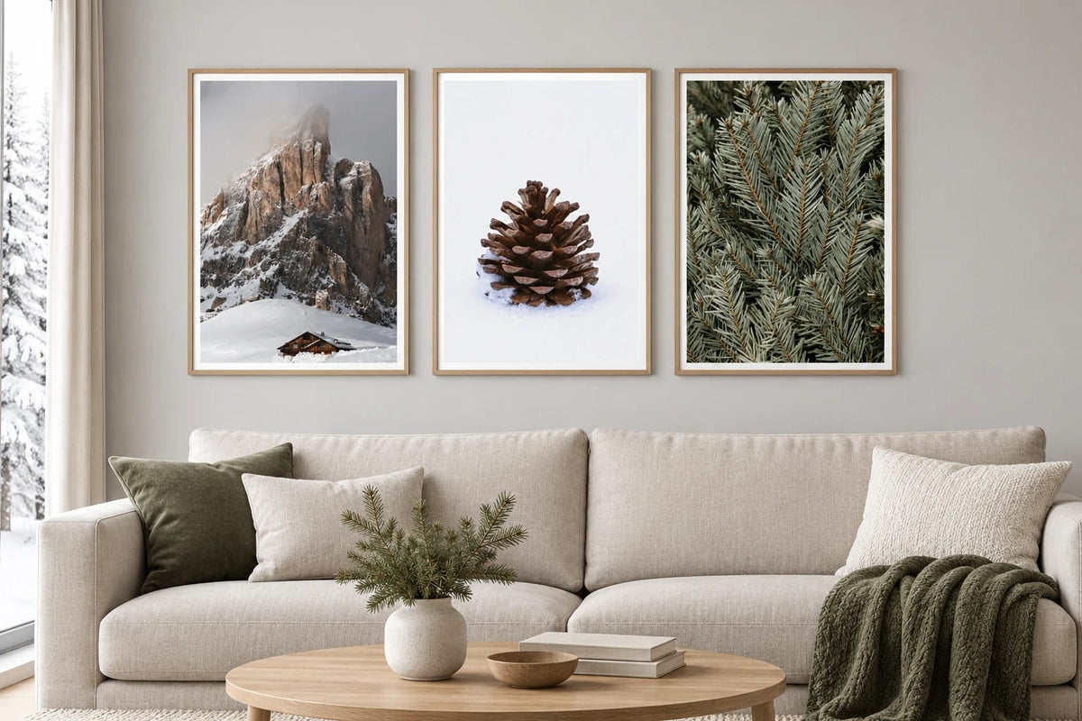 Three winter prints hang above a light sofa.