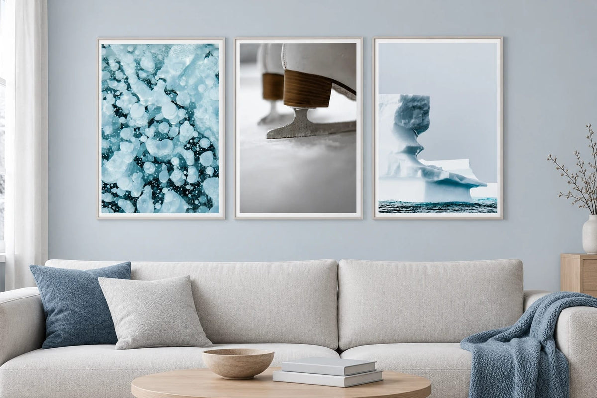 Three winter prints hang above a light sofa.