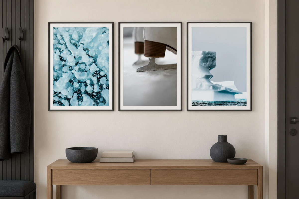 Three winter scenes hang above an oak console in an entryway.