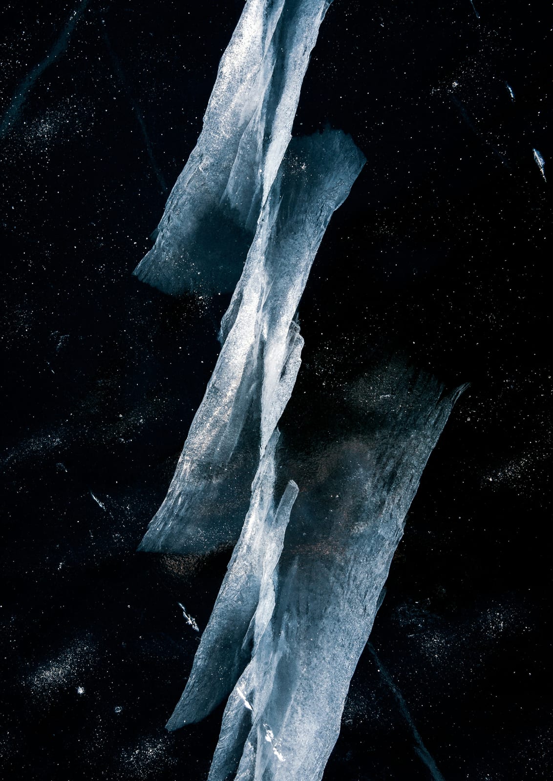 Clear angular ice fragments stand against a black background.
