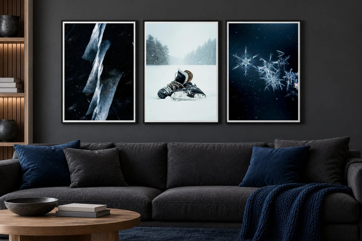 Three winter prints hang above a dark sofa.