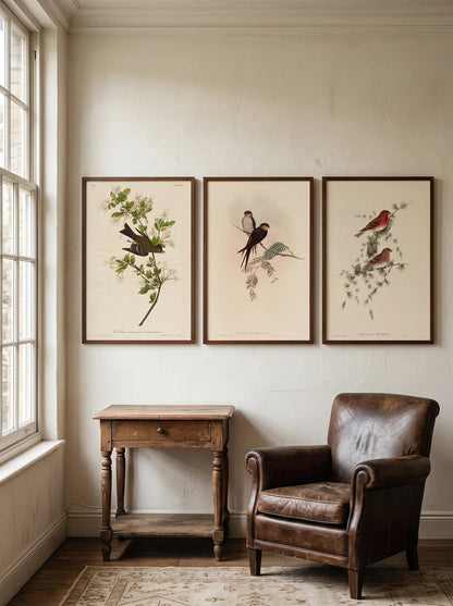 Three prints above a small table beside a leather chair.