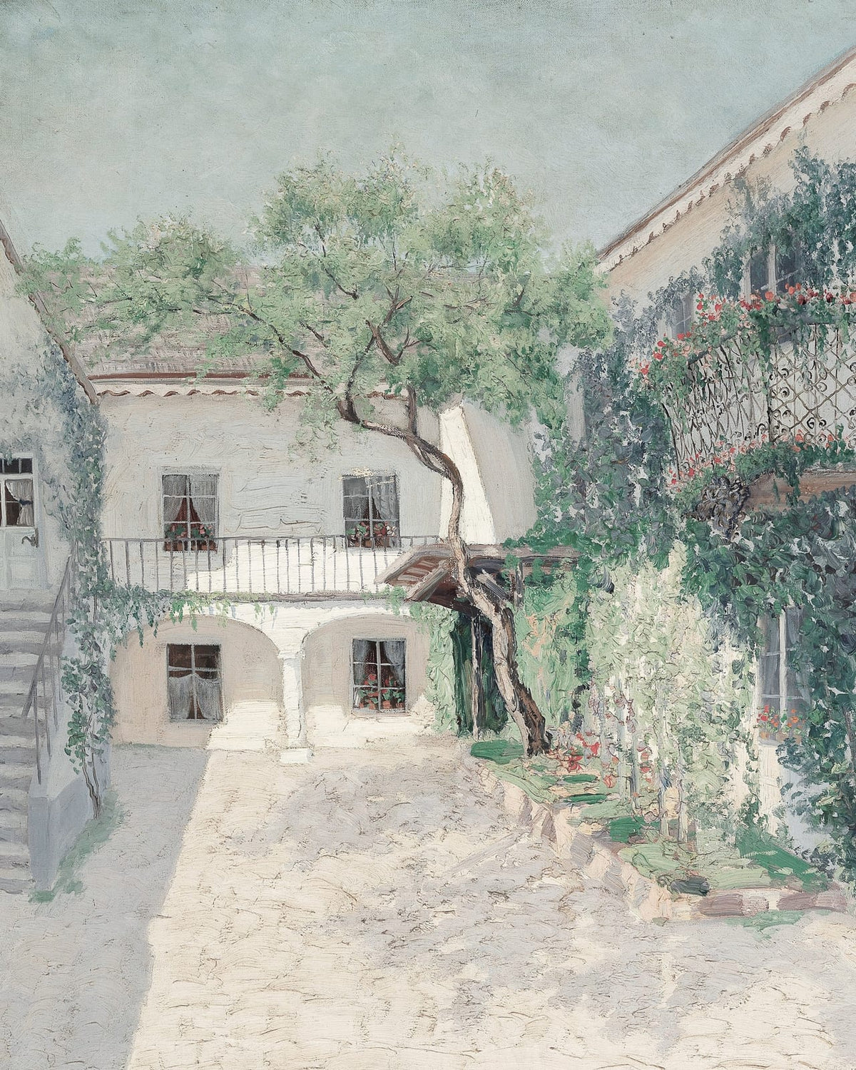 A tree and flowers in a sunny courtyard.