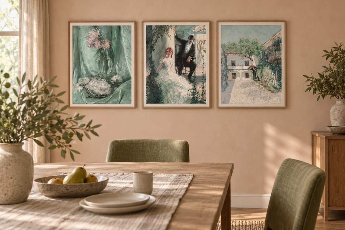 A flower, figure, and courtyard print trio above a dining table.