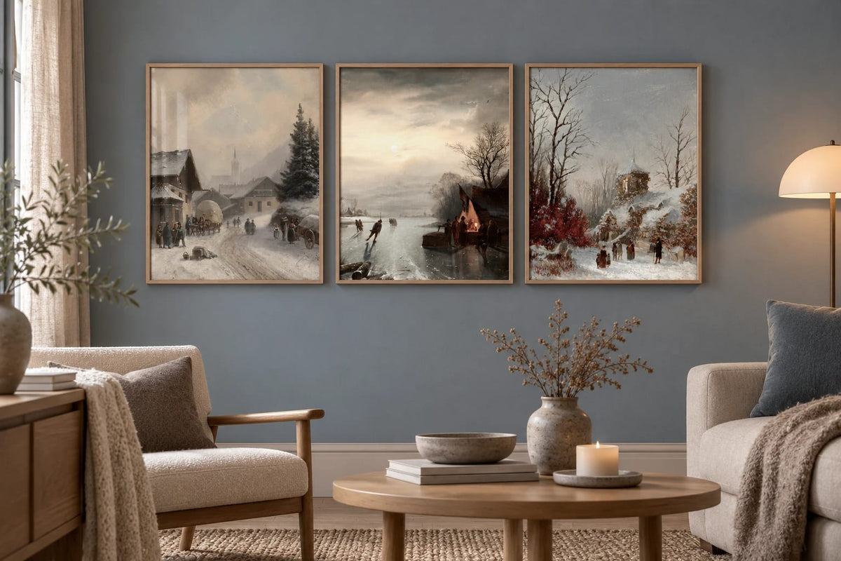 A village landscape print trio on a blue-gray living room wall.