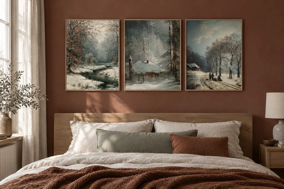 A winter forest print set displayed above a bed.