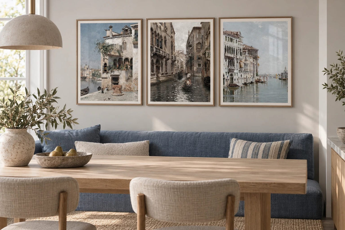 A cityscape print trio above a blue sofa.