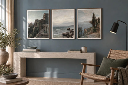 A castle and coastal print set above a pale stone console.