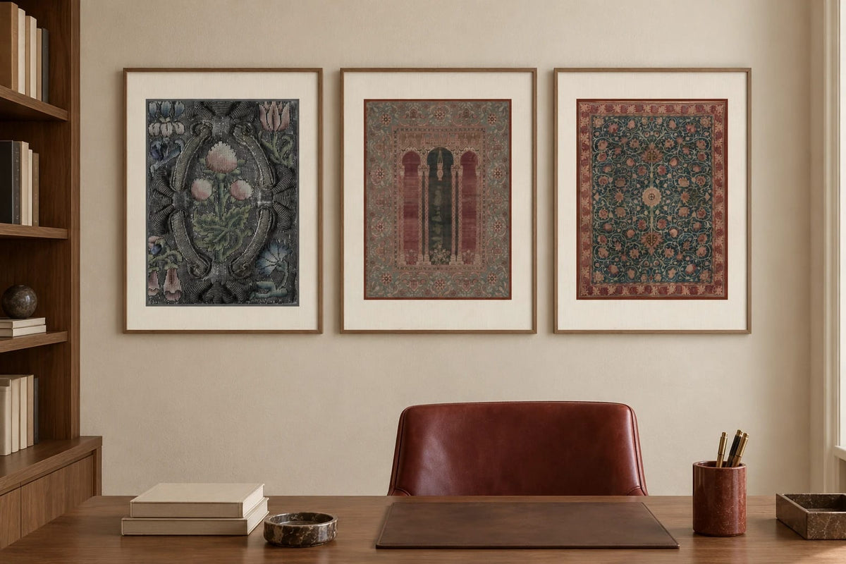 Ornamental prints hang above a wood desk beside a burgundy chair.