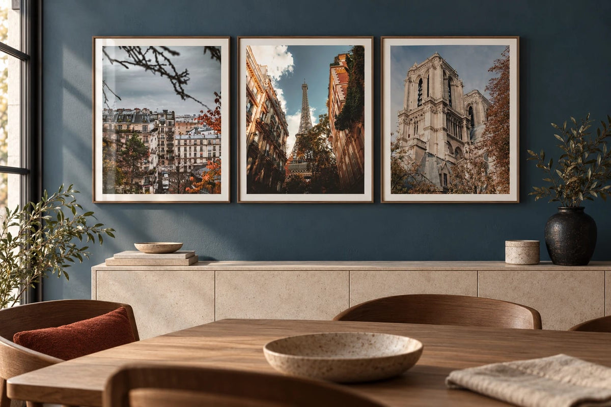 Paris cityscape prints grouped above a pale sideboard.