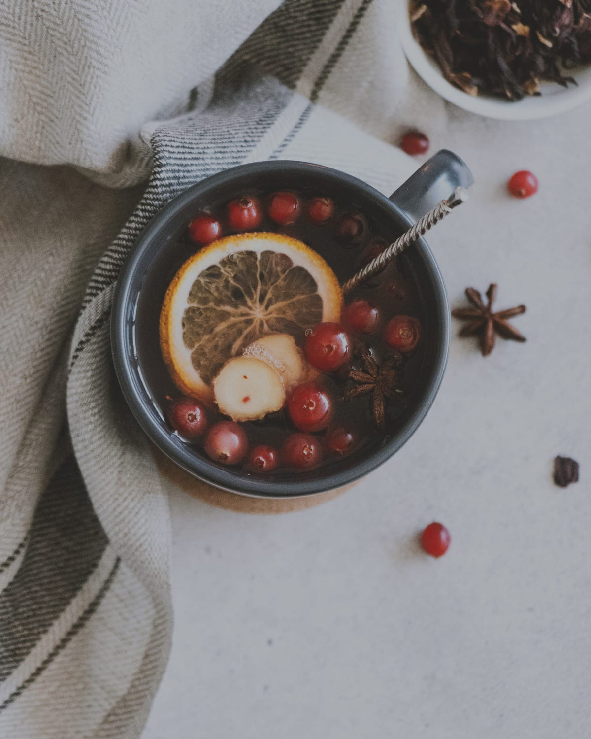 Citrus, berries, and spices arranged on a table.