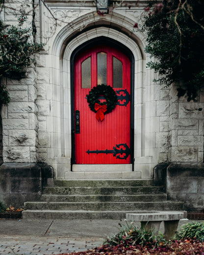 A red door decorated with a wreath.