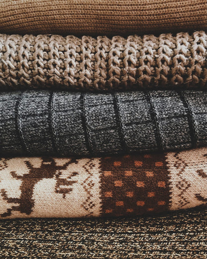 Folded knitted blankets with patterned textures.