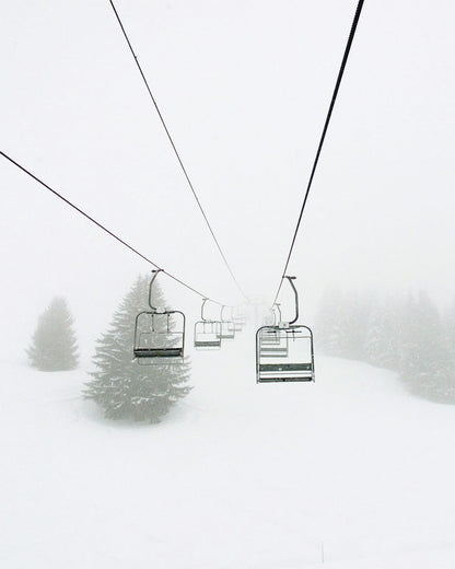 Chairlift seats above a snowy slope.