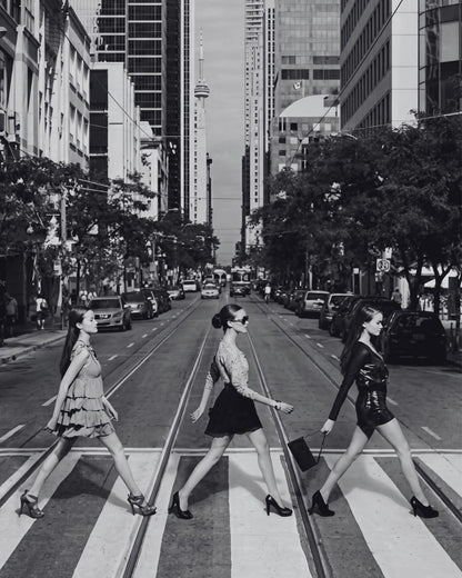 Three women crossing a city street.