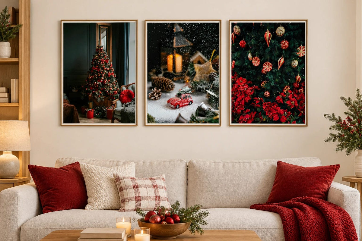 Three holiday prints hang above a light sofa with burgundy pillows.