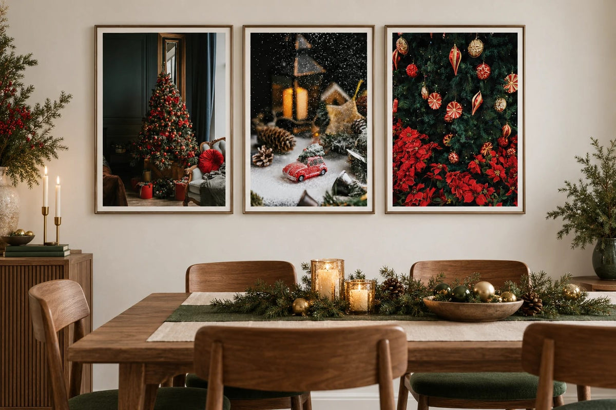 Three holiday prints hang above an oak table with a green runner and candles.