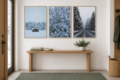 Three winter prints hang above an oak console in a bright entryway.