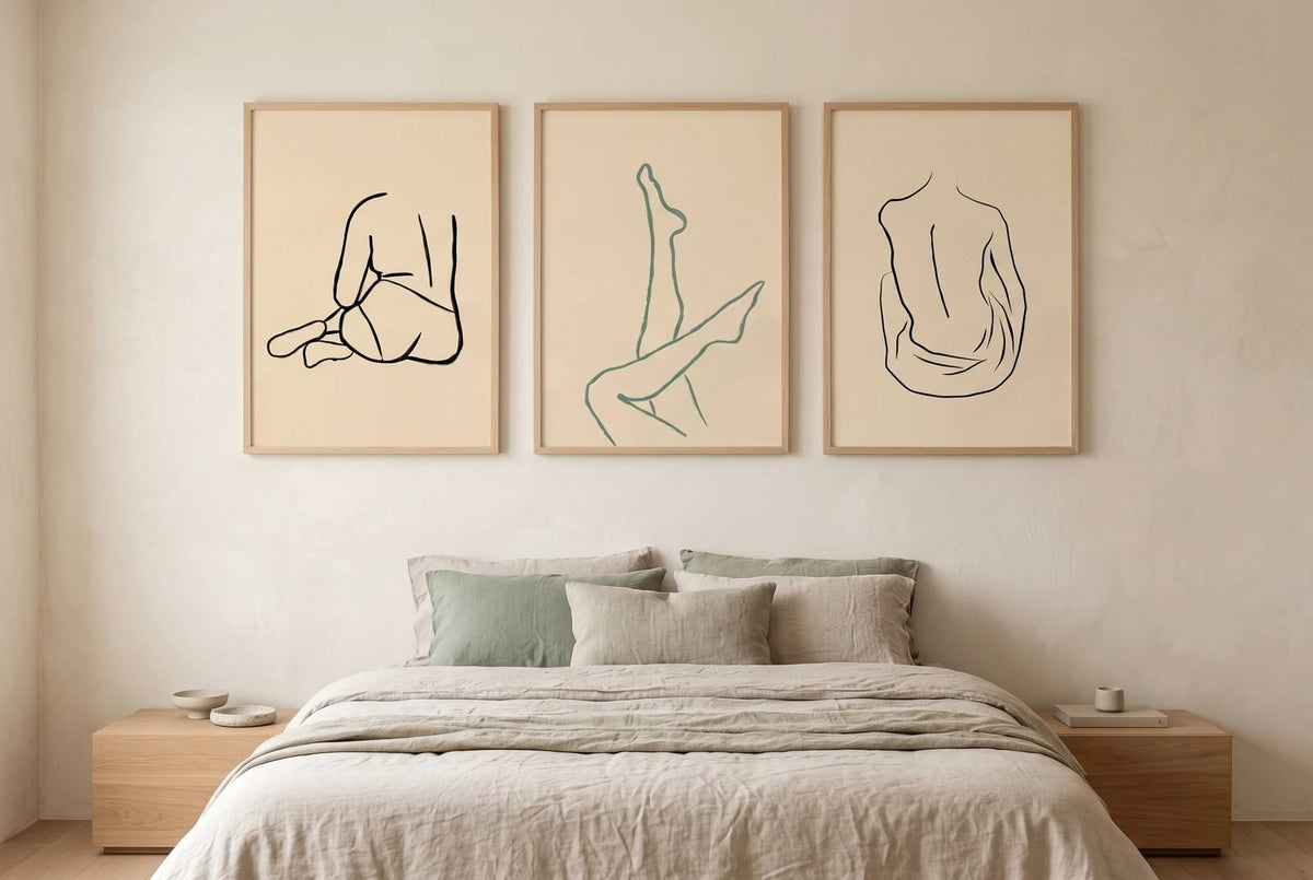 Figure line-art prints displayed above a bed with light linen.