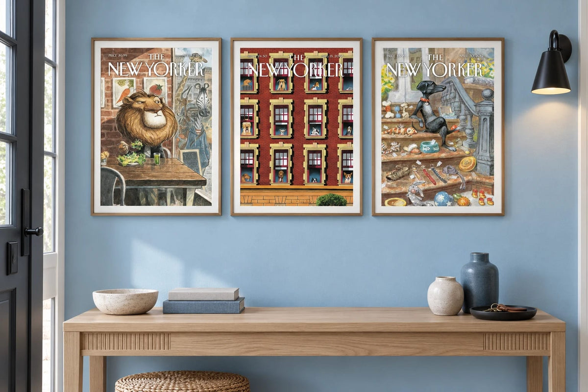 Three animal cover prints hang above a light wood console on a pale blue wall.