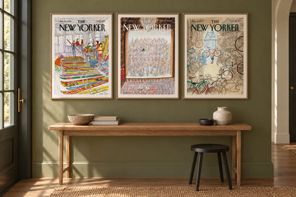 Three framed prints hang on an olive wall above a wood console beside a window.