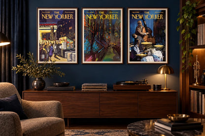 Three framed prints hang on a dark blue wall above a wood cabinet with a record player and brass lamp.
