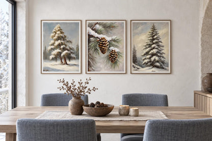 Three winter botanical prints hang above a wood dining table against a pale stone wall.