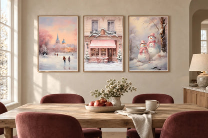 Three winter prints hang on a light wall above a long wood dining table.