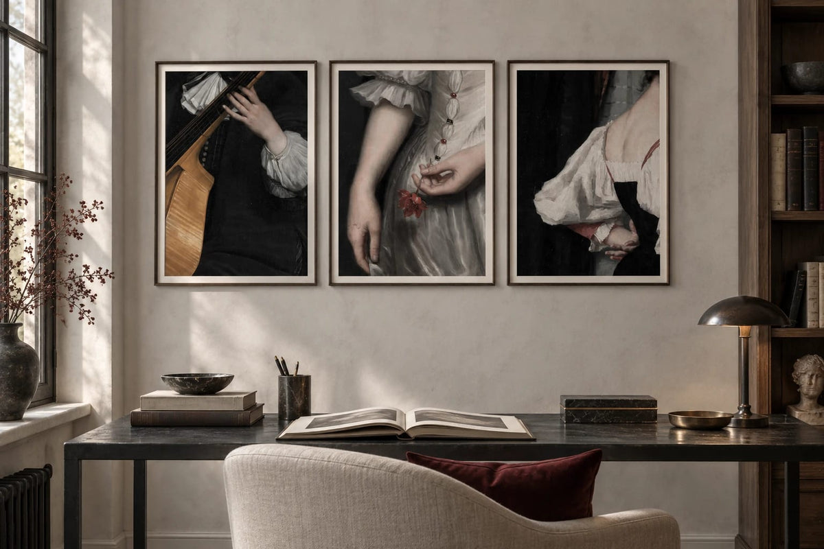 Three stage-detail prints hang above a desk in a light plaster library.