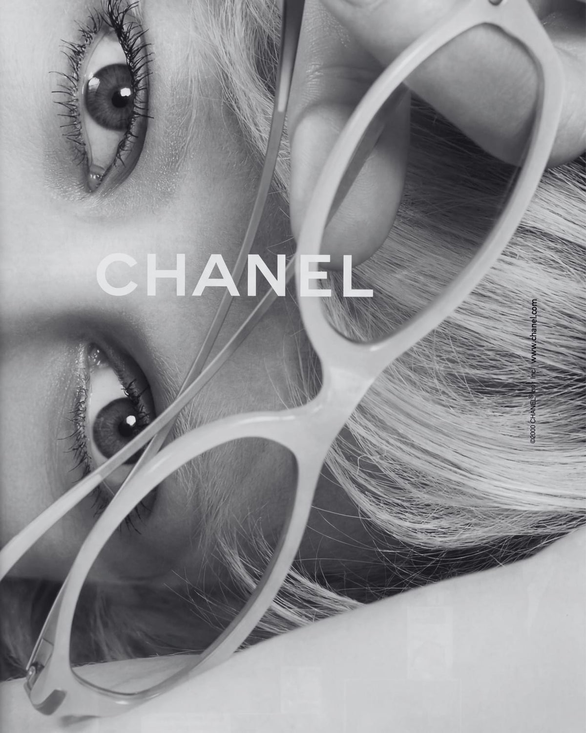 A portrait behind oversized glasses with CHANEL lettering.