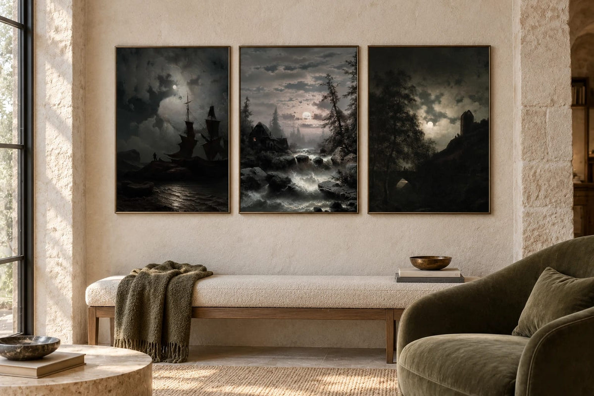 Three landscape prints hang beside a soft chair in a light stone reading nook.