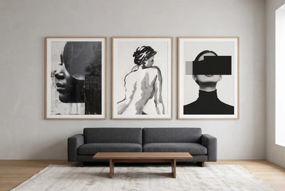 Monochrome portraits displayed above a graphite sofa in a light room.