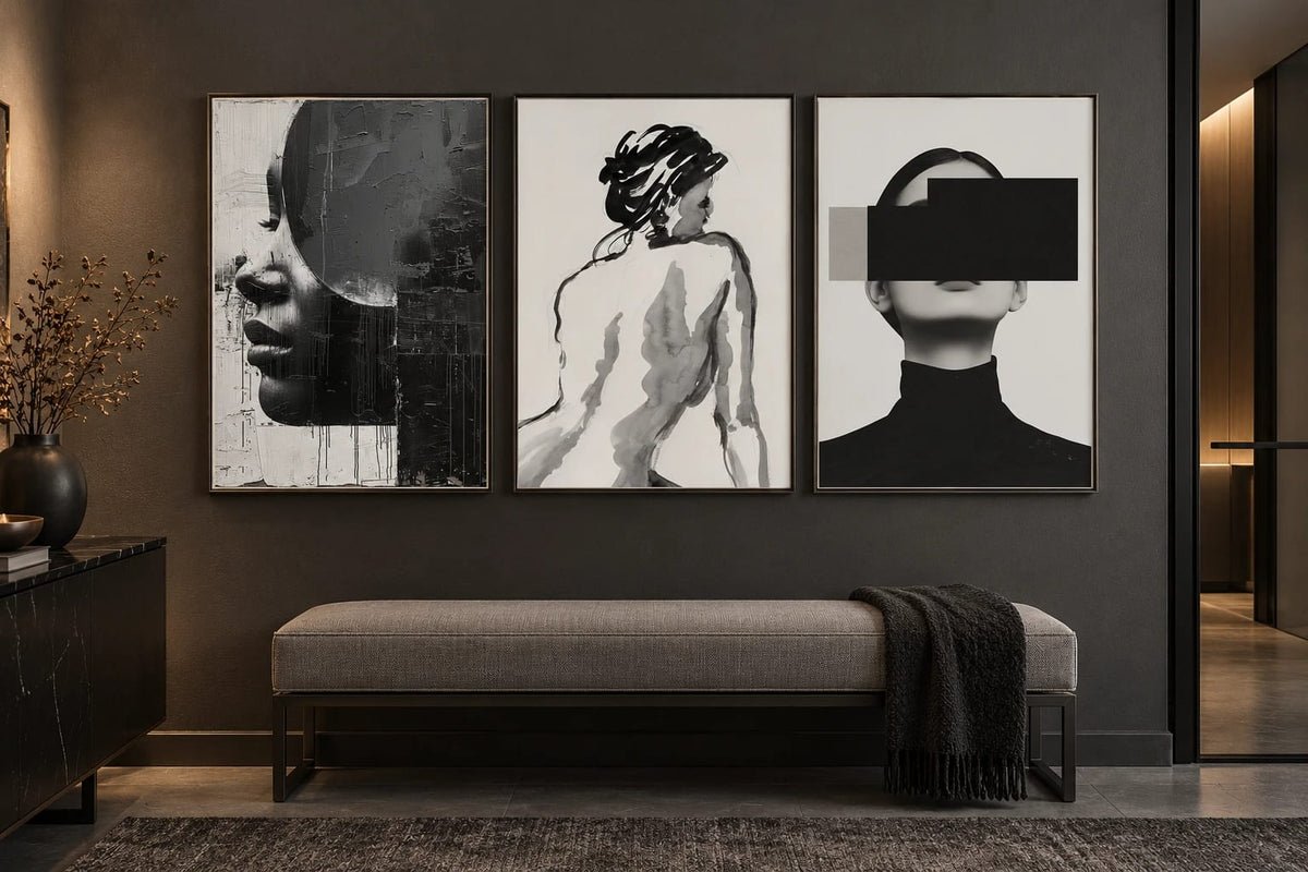Black-and-gray prints displayed on a graphite wall above a bench.