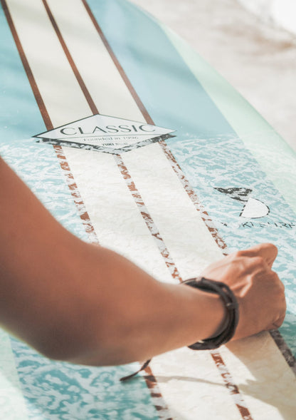hand holding a surfboard with CLASSIC lettering.