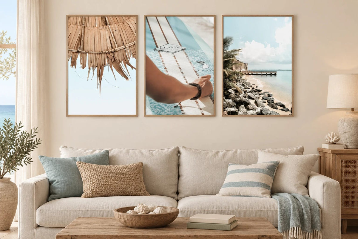 Beach prints above a light sofa with blue textiles.