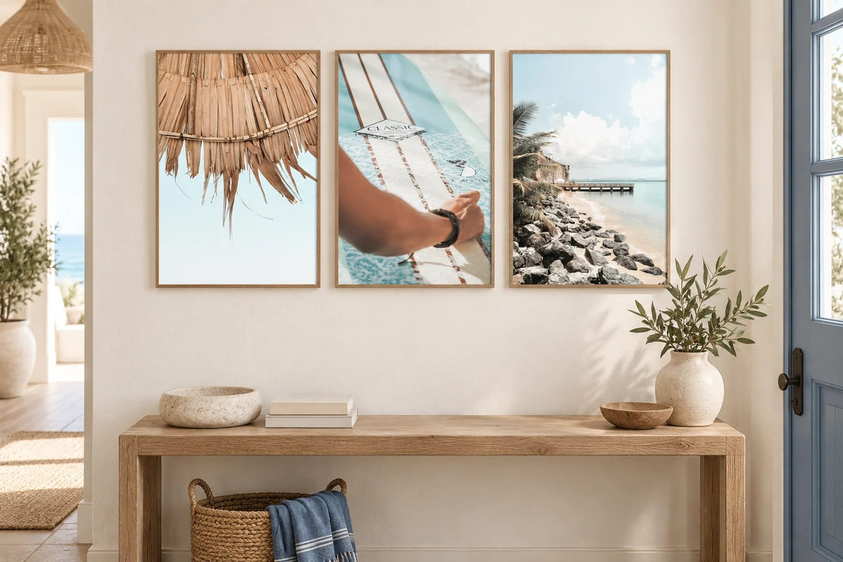 Three coastal prints above an oak console by a window.