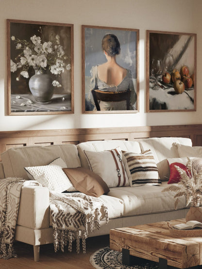 White flowers, a seated figure, and apples with glassware grouped in a room; frames are not included.